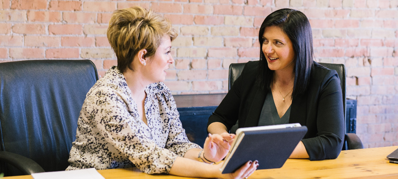 Photo of two people talking at a table